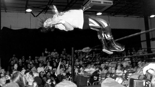 A black and white photo of Terry Funk mid-moonsault.